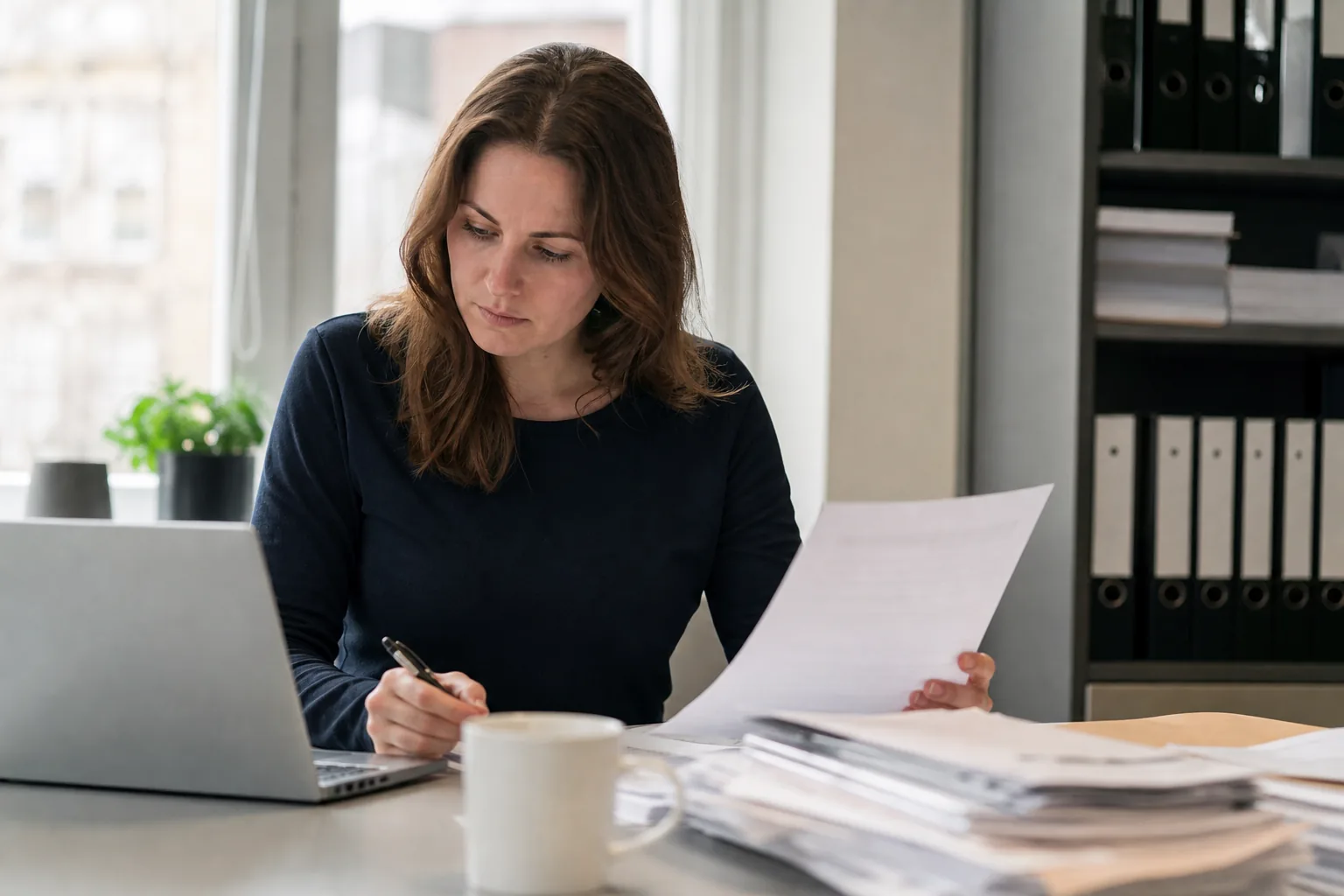 Administratief werk op een klein Nederlands kantoor. Beeld bij het artikel: Wanneer merk je in de loop van het jaar dat je 1.225 uur niet haalt?